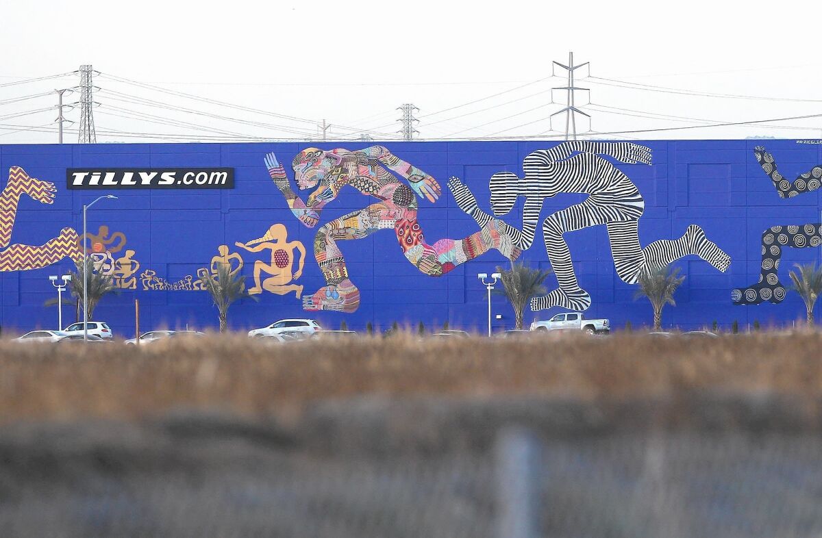 Zio Ziegler's giant mural inspired by San Francisco street art is seen on the side of Tilly's wall alongside the 405 freeway in Irvine.