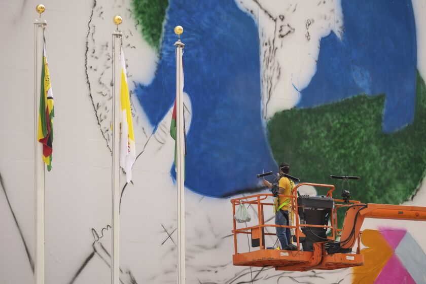 Artists work on a mural outside the United Nation Headquarters, Monday, Sept. 12, 2022, in New York. (AP Photo/Yuki Iwamura)
