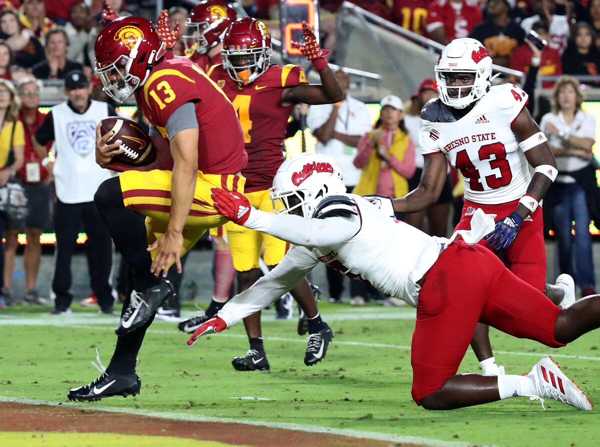 Caleb Williams leaps with the ball to score a USC touchdown.
