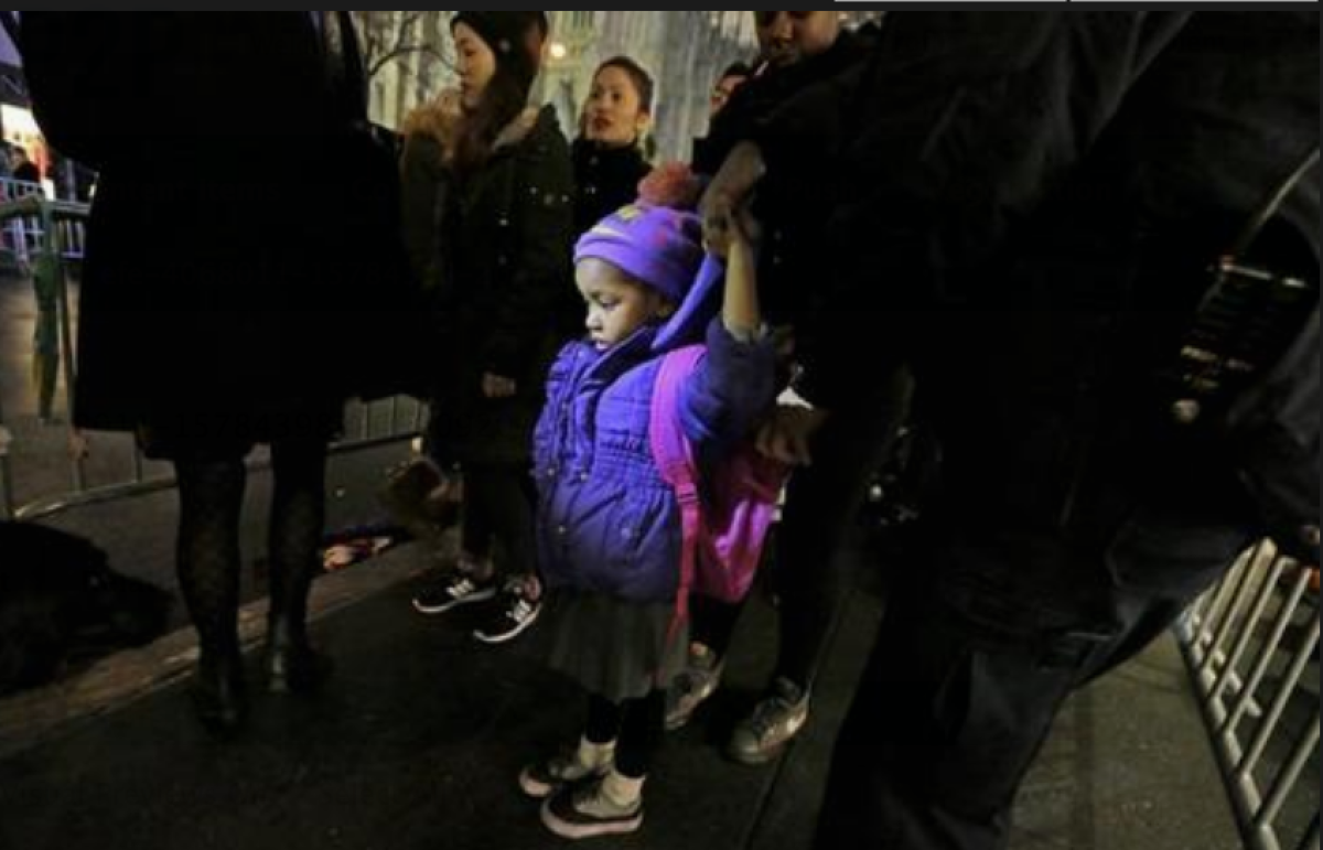 Un policía de Nueva York revisa el morral de una niña a la entrada de la edición 83 de la ceremonia de encendido del árbol de Navidad Rockefeller Center, el miércoles 2 de noviembre de 2015, en Nueva York (EE.UU.). EFE/Peter Foley/Archivo