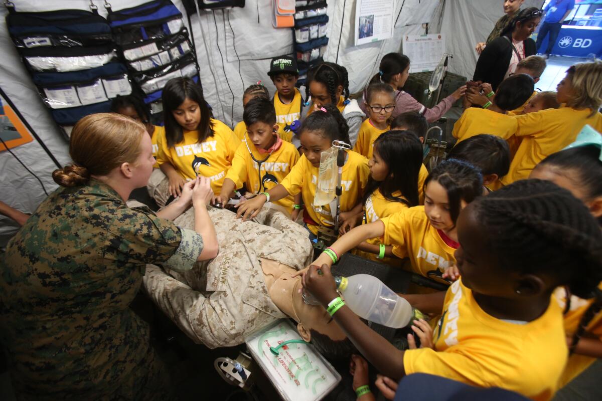 Lt. Jennifer Maas from Camp Pendleton shows students from Dewey Elementary School emergency procedures using a mannequin.