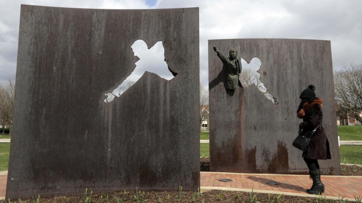 A visitor pauses Wednesday at the Landmark for Peace Memorial, which commemorates the site where Sen. Robert F. Kennedy announced news of Martin Luther King Jr.'s assassination in Indianapolis in 1968.