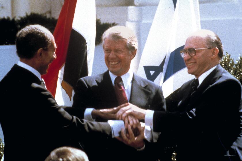 FILE - Egyptian President Anwar Sadat, left, U.S. President Jimmy Carter, center, and Israeli Prime Minister Menachem Begin clasp hands on the North lawn of the White House as they completed signing of the peace treaty between Egypt and Israel in Washington on March, 26, 1979. Egypt has threatened to void its decades-long peace treaty with Israel if Israel begins a large-scale offensive on Rafah, where some 1.4 million Palestinians shelter in densely-packed tent camps on the border with Egypt. (AP Photo/Bob Daugherty, File)