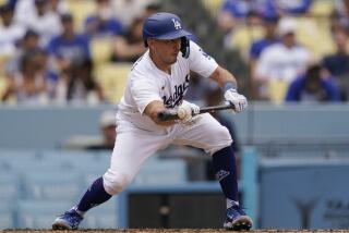 Los Angeles Dodgers' Austin Barnes bunts the ball leading to James Outman.
