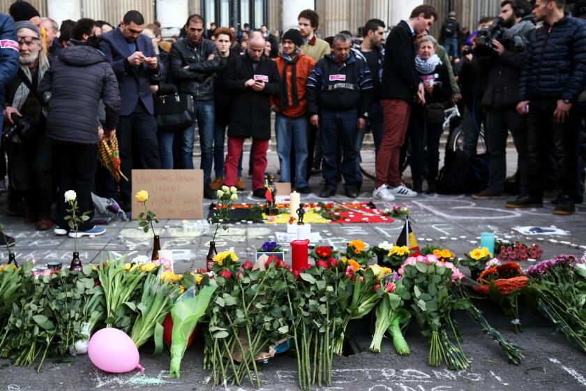 People leave tributes at the Place de la Bourse after the attacks in Brussels.