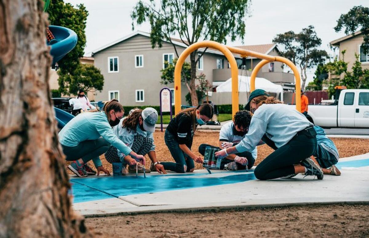 Volunteers, including Costa Mesa City Councilman Manuel Chavez, touch up a Shalimar Park painting for Love Costa Mesa 2021.