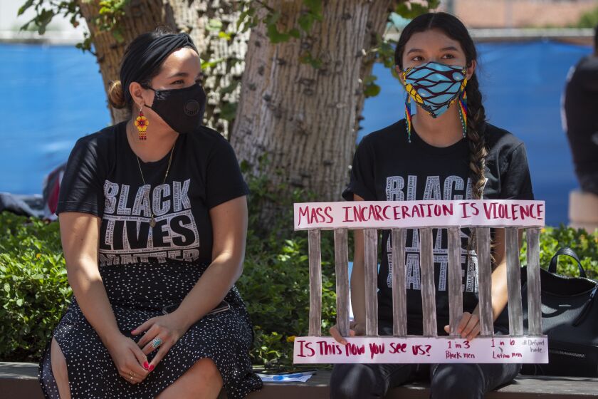SANTA ANA, CA - JULY 14: Karla Navarro, left, and Tanya Navarro, both Black Lives Matter supporters, show their support for the continued use of masks and the approval continuance of a local health emergency outside where the Orange County Board of Supervisors was holding its regular board meeting at the Orange County Hall of Administration on Tuesday, July 14, 2020 in Santa Ana, CA. The protesters also want John Wayne Airport to be renamed and to defund the police. OC Supervisors also discussed a file status report and approve continuance of local health emergency and local emergency related to Novel Coronavirus (COVID-19) and set a review to continuing local emergency and every 30 days after until terminated. They also discussed a resolution in support of a ban on affirmative action introduced by Supervisors Michelle Steel and Don Wagner and a proposal from Supervisors Lisa Bartlett and Doug Chaffee to alter the county's term limits for supervisors. (Allen J. Schaben / Los Angeles Times)