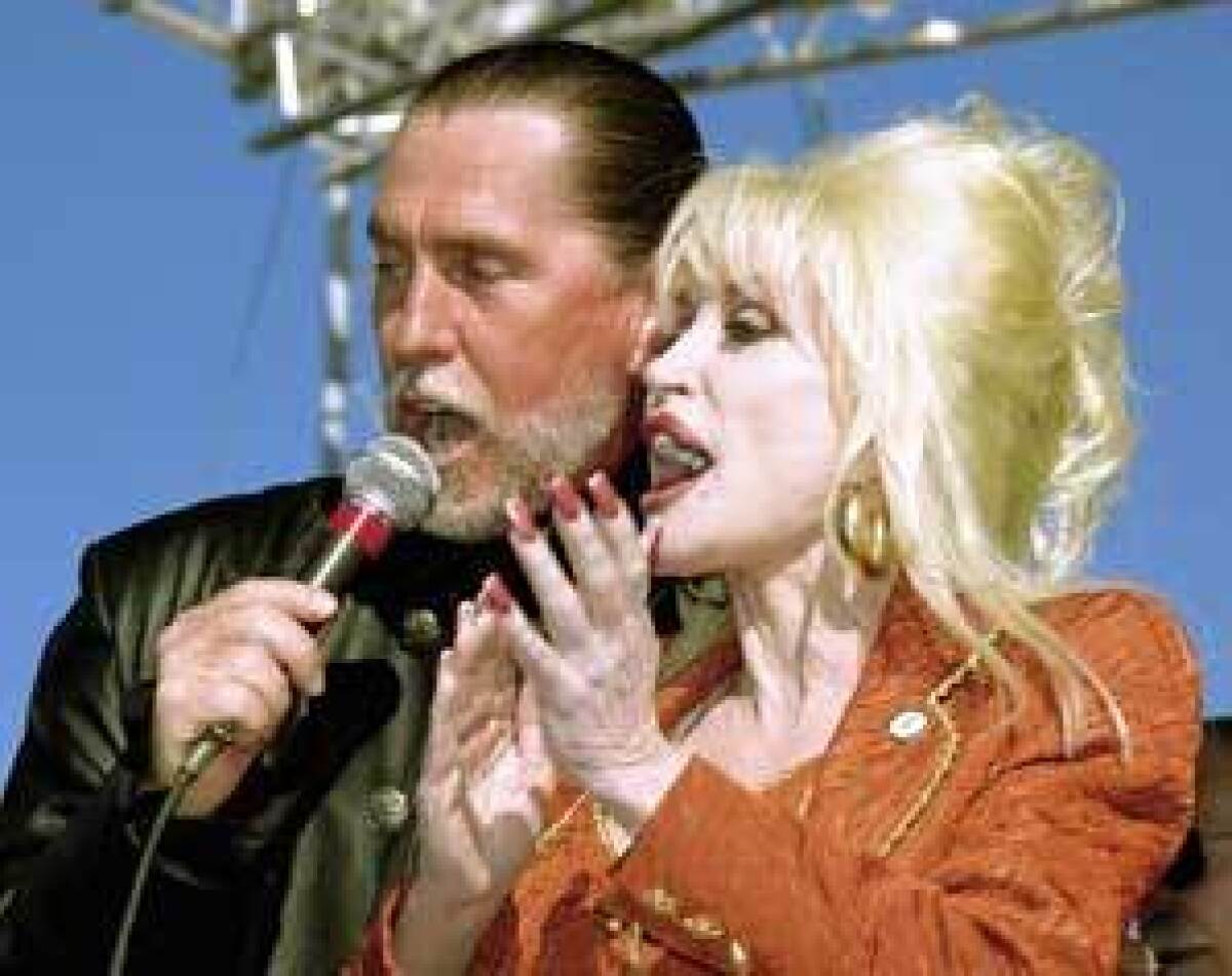 SIBLING REVELRY: Randy and Dolly Parton share a microphone at the Carolina Crossroads groundbreaking.