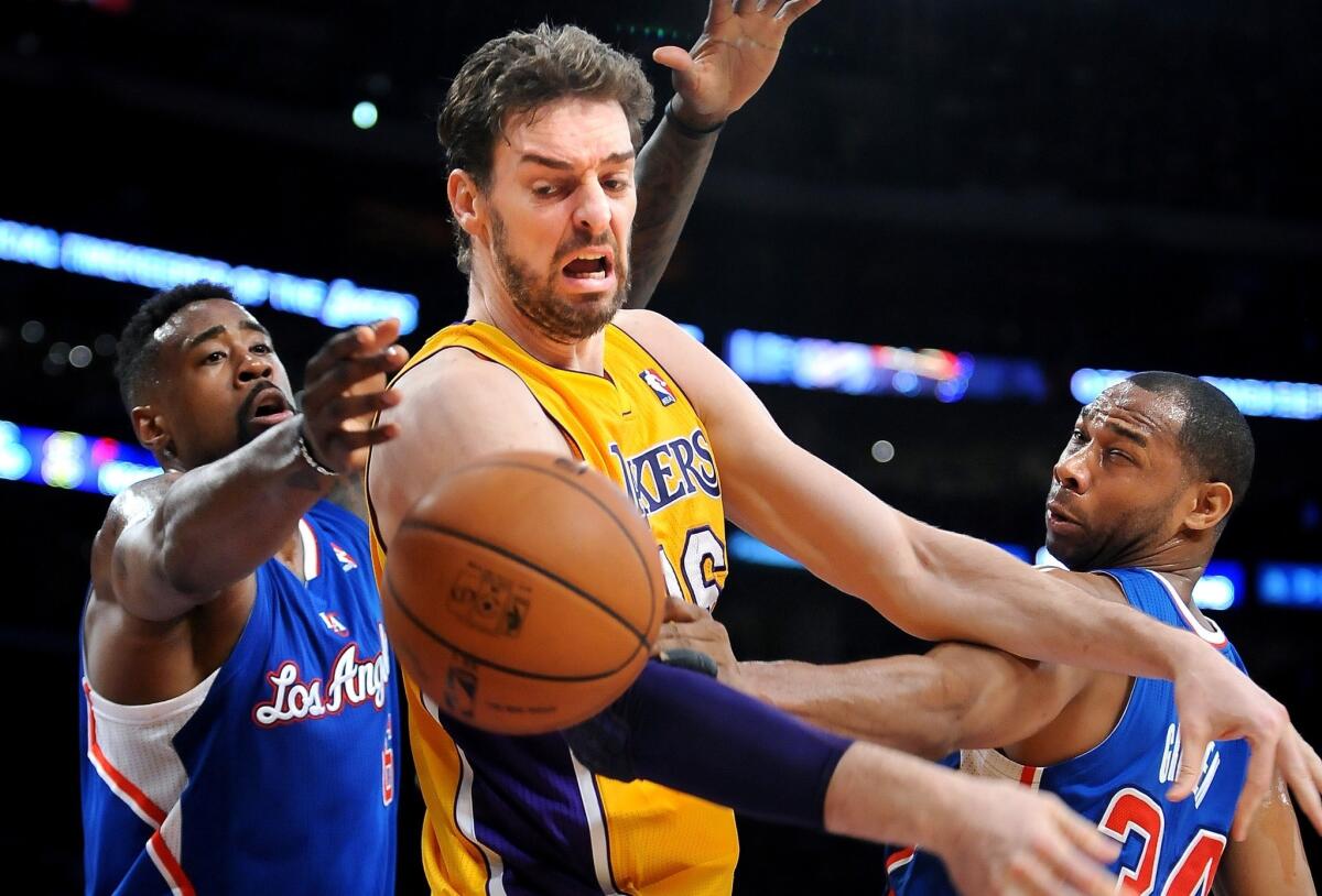Lakers power forward Pau Gasol loses control of the ball against the double-team defense of Clippers center DeAndre Jordan, left, and forward Willie Green in the first half.