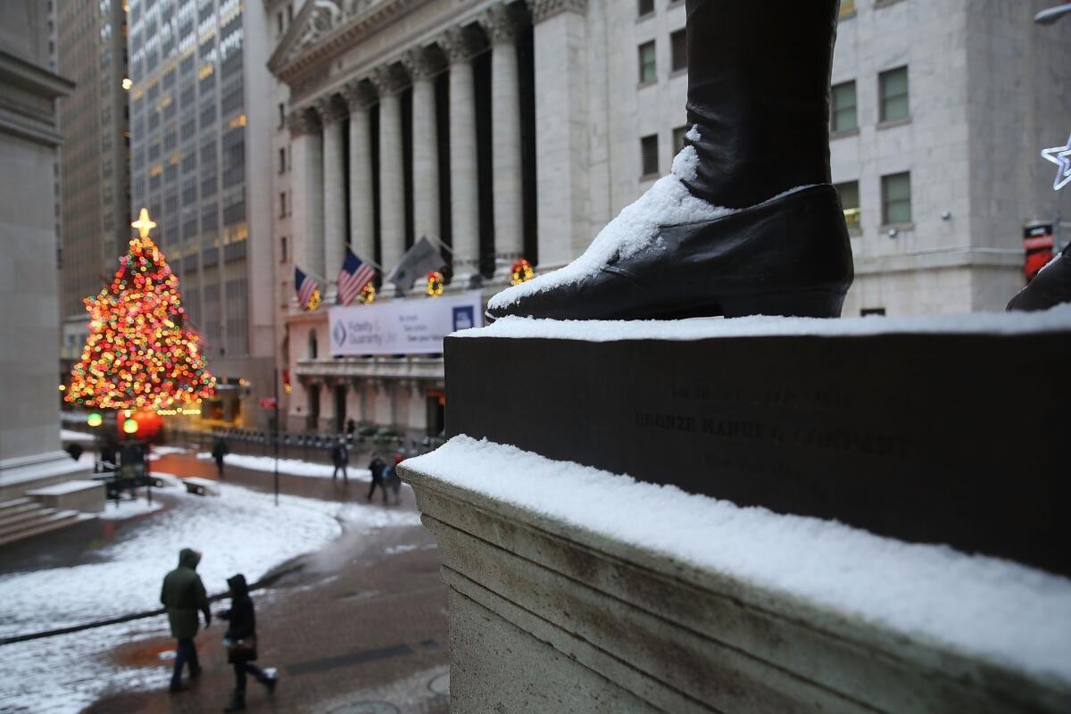 Snow dusts a statue of George Washington on Wall Street.