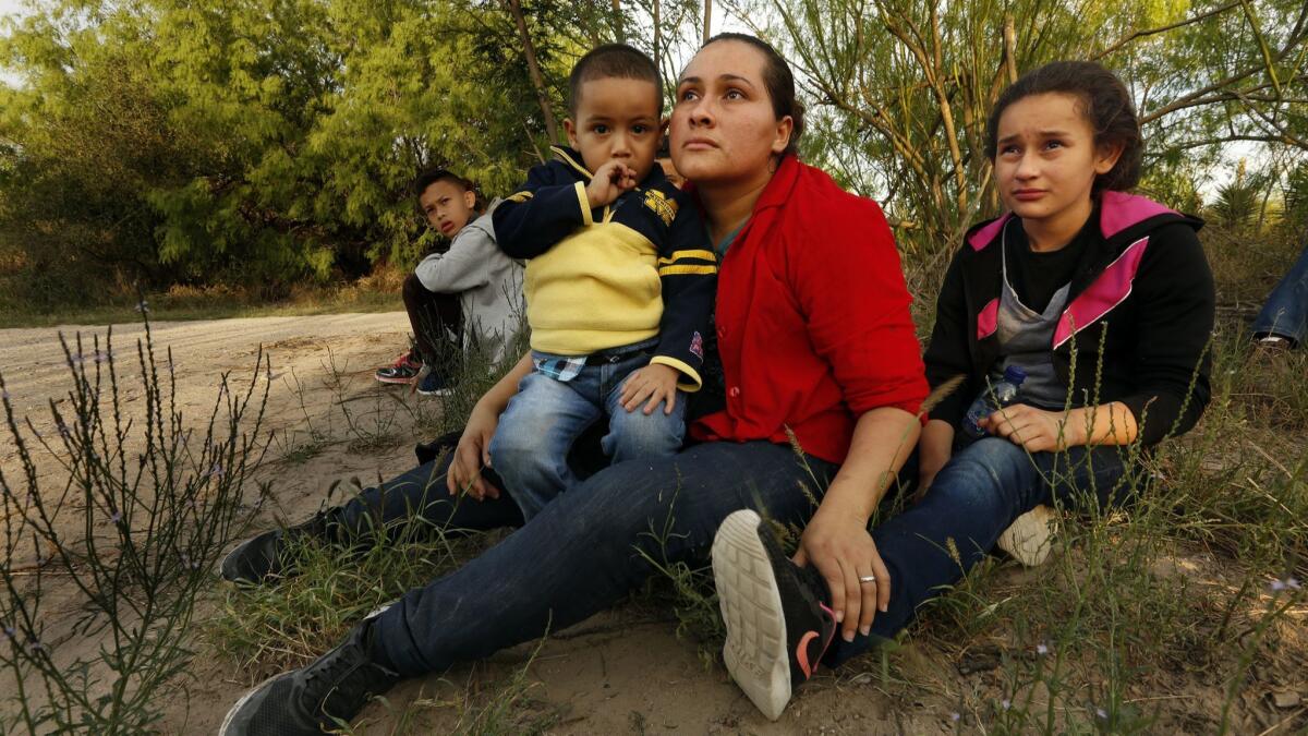 Hayti Alvarado, 26, holds son Esteban, 3, as daughter Gabriella, 11, cries after they were detained by Border Patrol agents near McAllen, Texas.