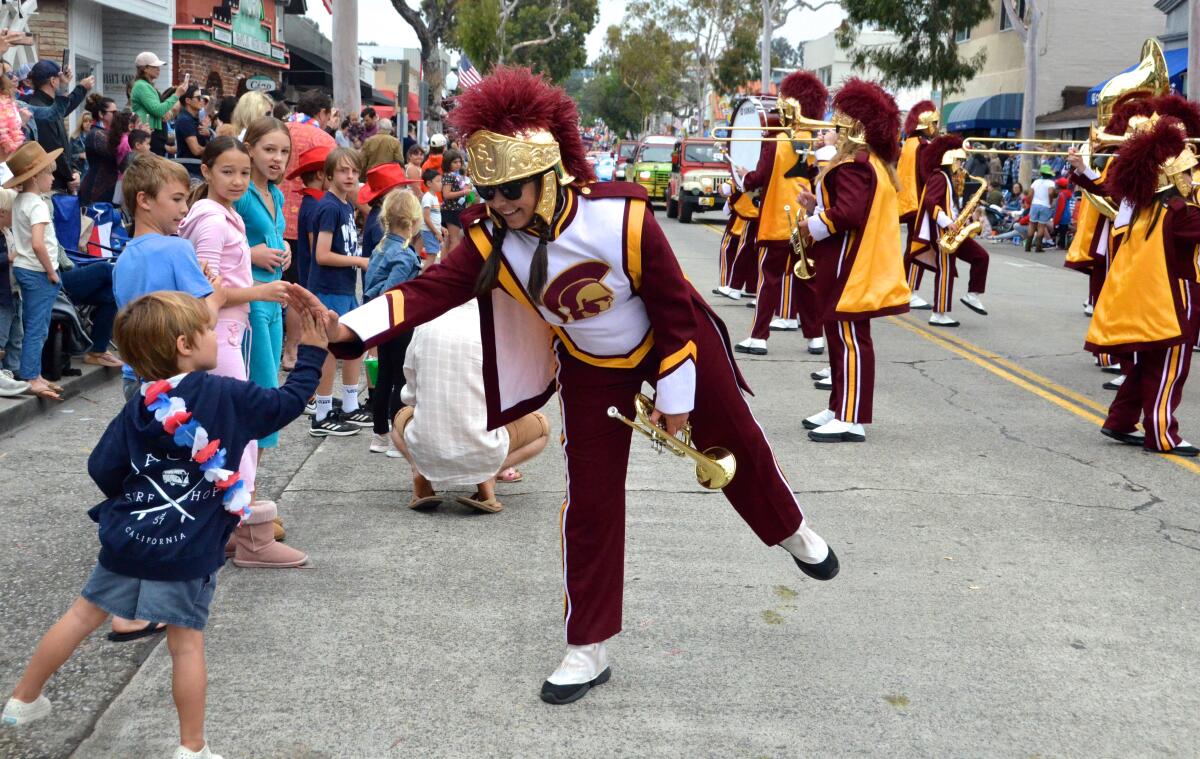 A member of the USC Trojan marching band greets kids at the parade.