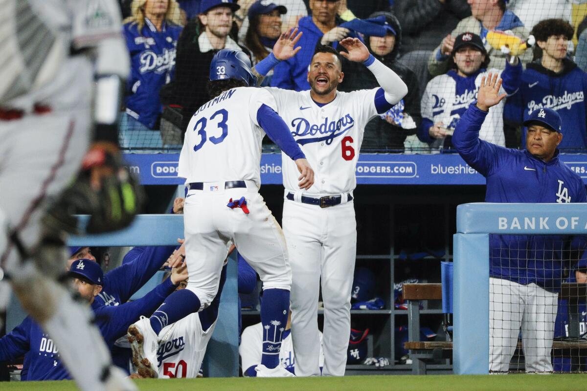 James Outman, left, is congratulated by Dodgers teammate David Peralta.