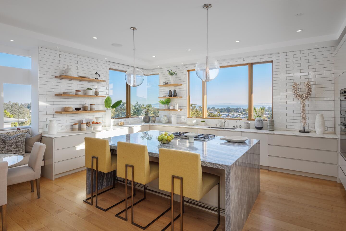 The kitchen has an island with seating and windows with views.