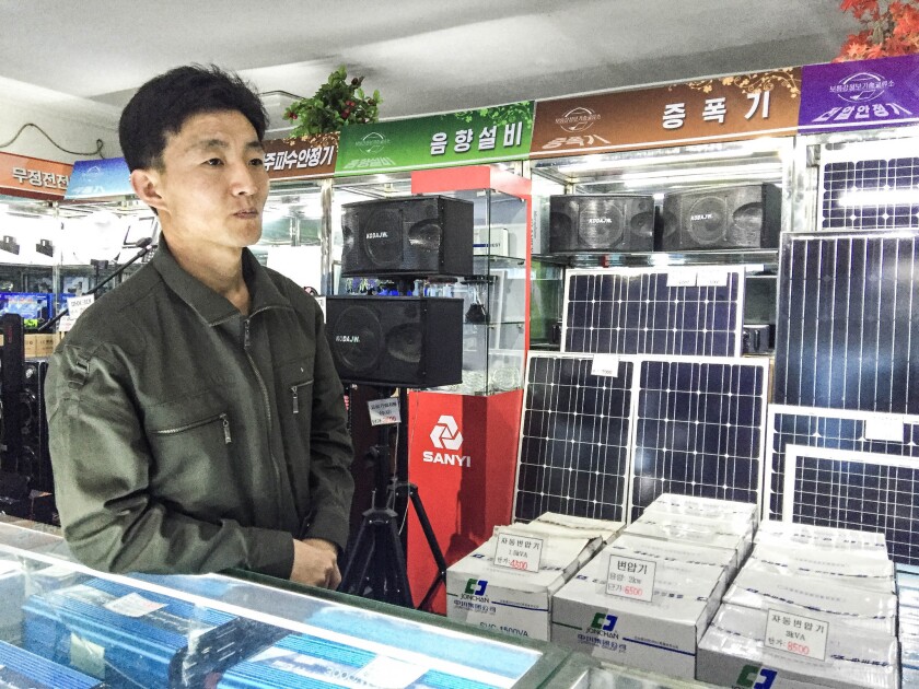 A clerk at the Pothonggang Information Technology Center stands in front of a display of solar panels for sale in Pyongyang, North Korea.