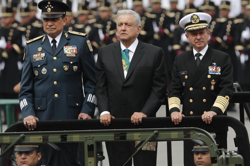 FILE - In this Sept. 16, 2019 file photo, Mexican President Andres Manuel Lopez Obrador, center, Defense Secretary Luis Crescencio Sandoval, left, and Navy Secretary Vidal Francisco Soberon, ride in an open vehicle during the Independence Day military parade in the Zocalo, in Mexico City. Lopez Obrador expanded the military's role in Mexico's economy Friday, March 19, 2021, announcing he will give the navy part ownership of the multi-modal rail and port link across the country’s southern isthmus. (AP Photo/Marco Ugarte, File)
