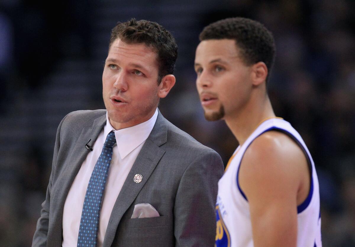 Warriors interim Coach Luke Walton talks to star guard Stephen Curry during a game against the Clippers in Oakland on Nov. 4.