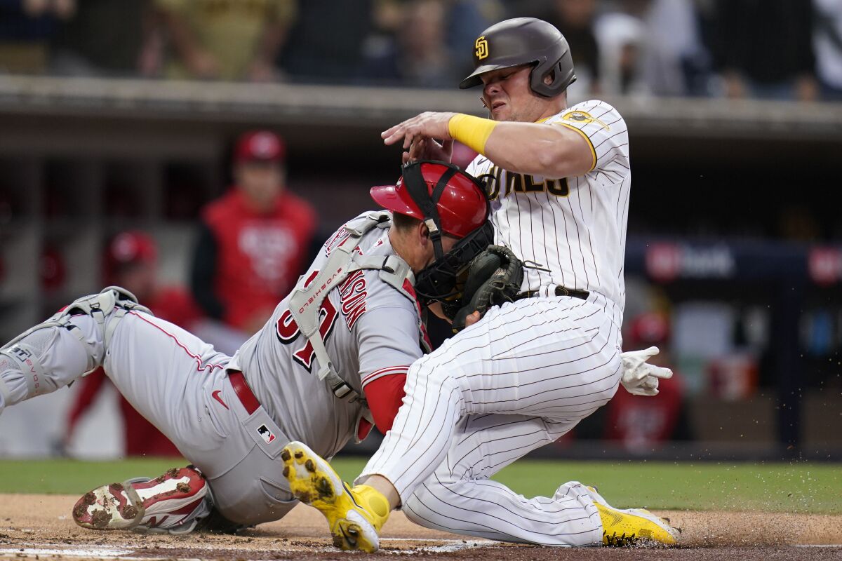 Cincinnati Reds catcher Tyler Stephenson, left, tags out San Diego Padres' Luke Voit, trying to score from first off a double by Jurickson Profar during the first inning of a baseball game Tuesday, April 19, 2022, in San Diego. (AP Photo/Gregory Bull)