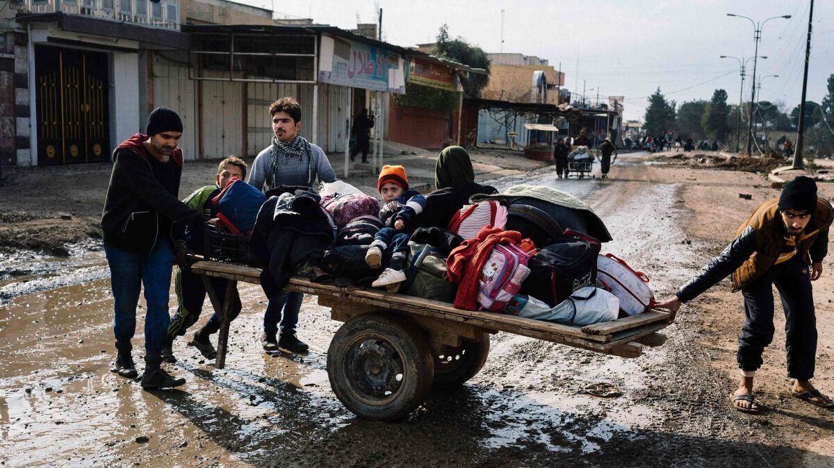 Iraqis move their belongings in Mosul's Zahra neighborhood on Jan. 8, 2017, as they flee with other civilians during military operations against Islamic State.