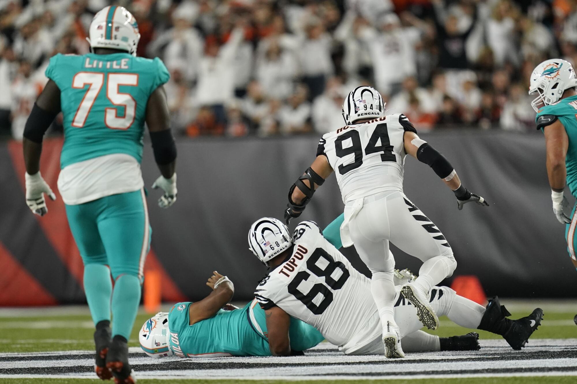 Dolphins quarterback Tua Tagovailoa (1) is on his back after taking a hit from the Bengals' Josh Tupou (68).