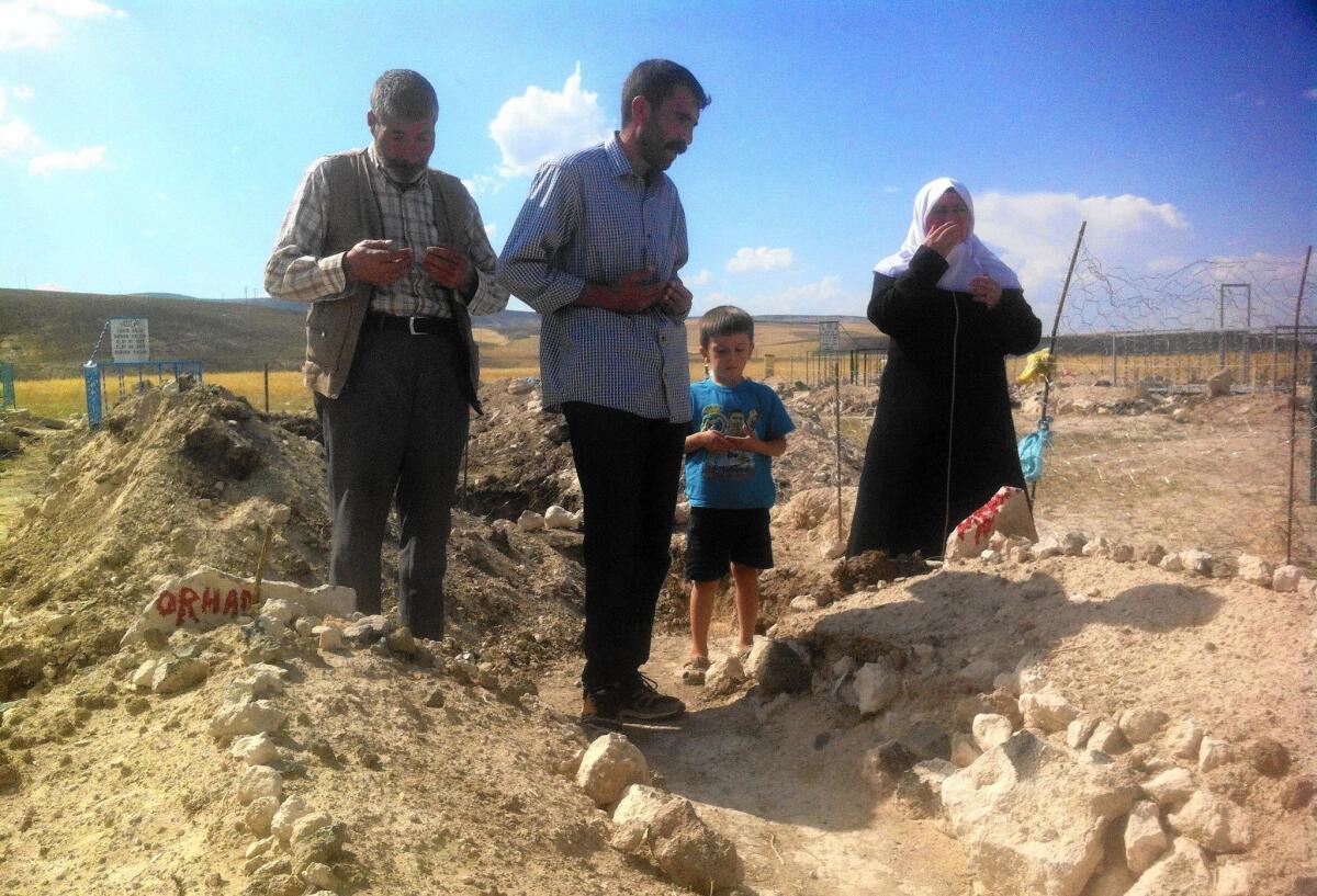 Relatives visit the graves of two Kurdish boys slain in August by Turkish security forces. Authorities accuse Muhammet Aydemir, 15, and Orhan Arslan, 17, of being Kurdish guerrillas. Their families say the pair were innocents slain in cold blood.