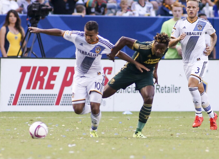 Galaxy forward Giovani dos Santos and Portland midfielder George Fochive iduring an MLS game on Oct. 18.