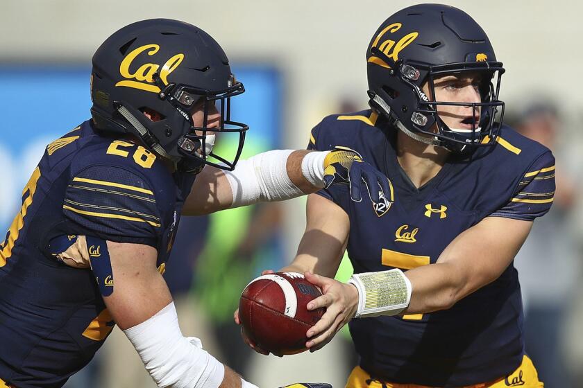 California quarterback Chase Garbers, right, hands off the ball to Patrick Laird (28) during the first half of an NCAA college football game against Washington Saturday, Oct. 27, 2018, in Berkeley, Calif. (AP Photo/Ben Margot)