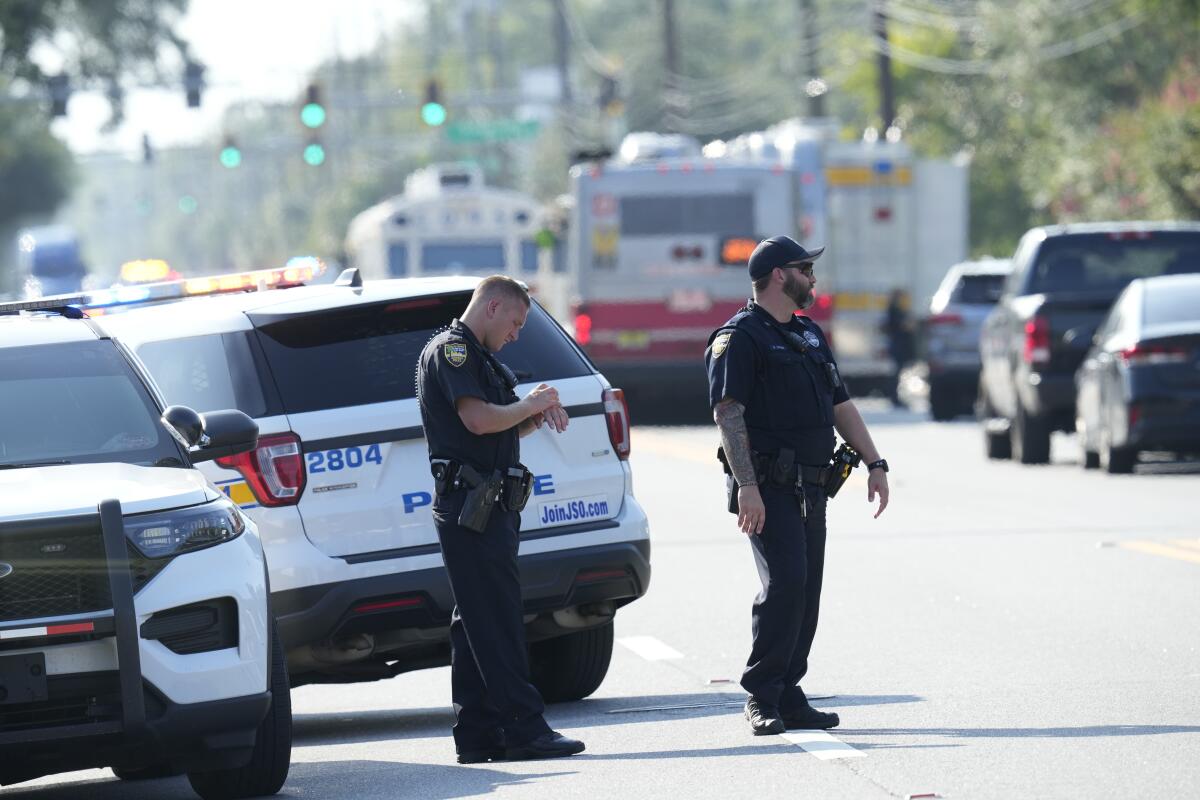 Jacksonville police officers block the perimeter of the scene of a mass shooting.