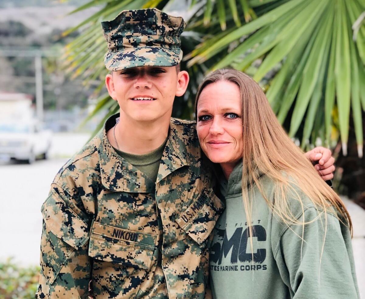 A young Marine poses for a photo with his mother