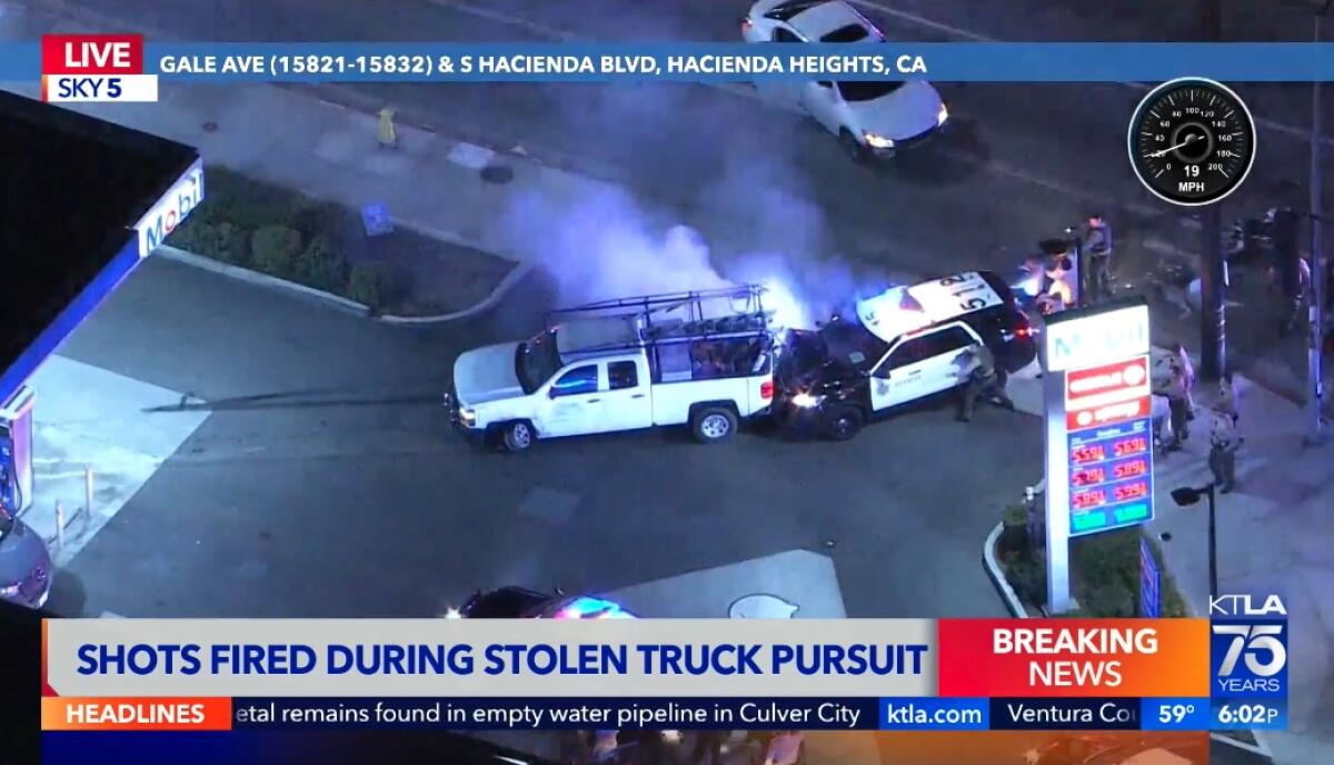 A sheriff SUV rammed into the back of a pickup truck with smoke rising as deputies point guns