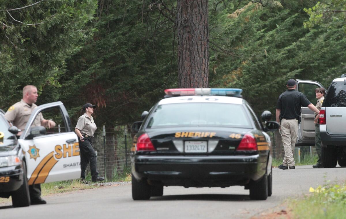 Shasta County Sheriff's deputies investigate the scene of a triple homicide in Shingletown, Calif.