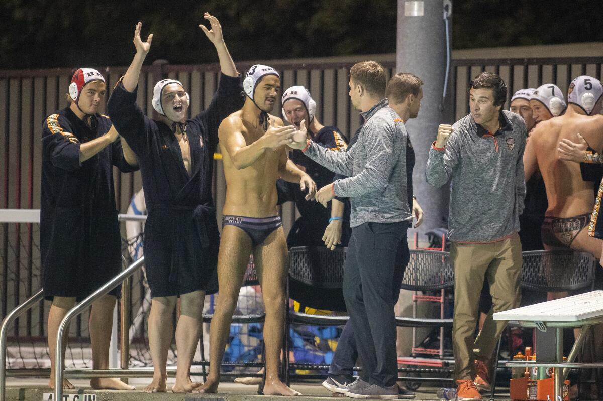 Huntington Beach coach Sasa Branisavljevic congratulates Cooper Haddad after the team beat Orange Lutheran 11-5 in the first round of the CIF Southern Section Division 1 playoffs at Santiago Canyon College in Orange on Thursday.
