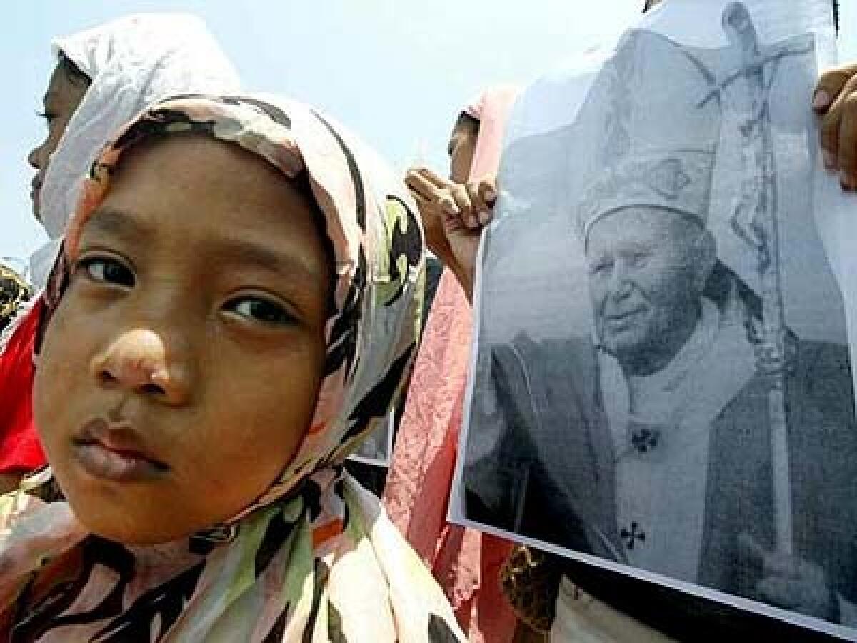A Filipina Muslim attends a prayer rally for Pope John Paul II in front of a church in Quezon City, north of Manila, last week. Many Filipino Catholics and Muslims hope that John Pauls successor will continue his efforts to reach out to Muslims.