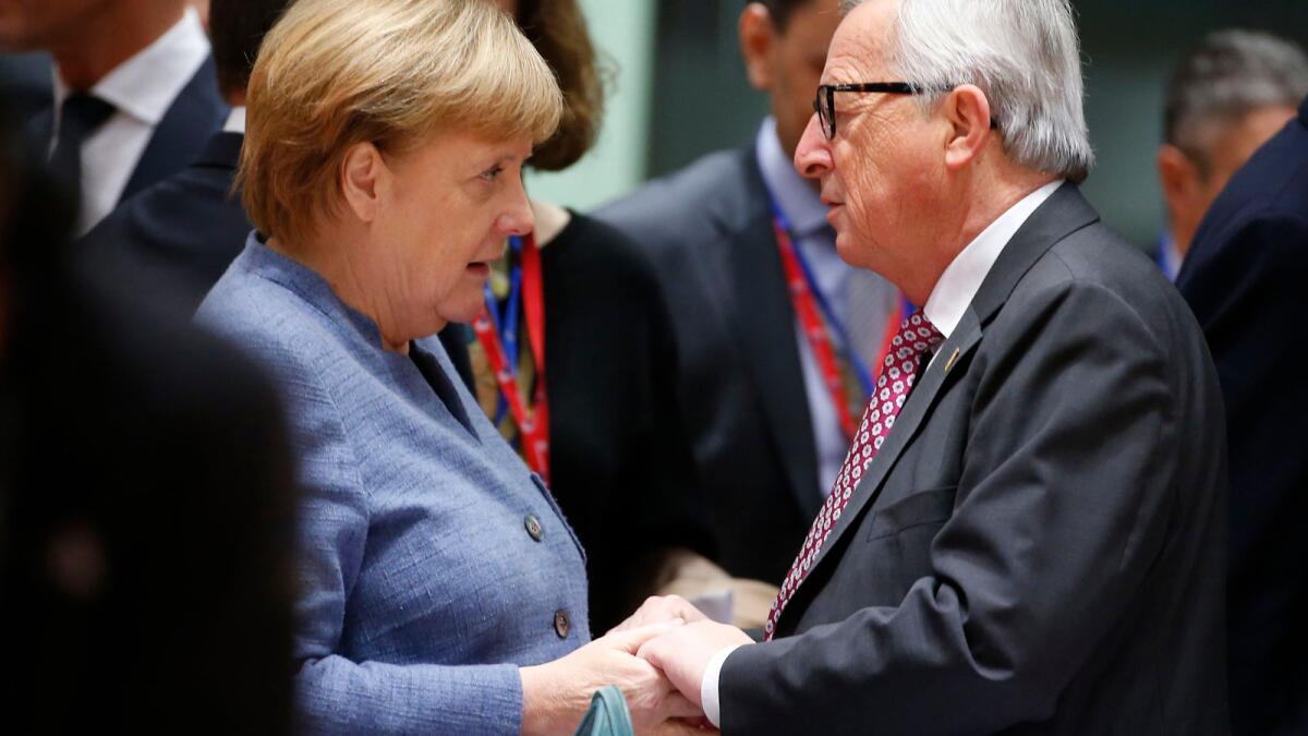 German Chancellor Angela Merkel and European Commission President Jean-Claude Juncker confer at the European Council meeting on the Brexit deal in Brussels.