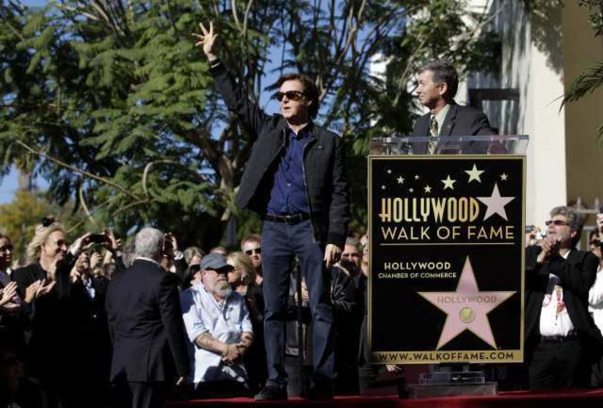 Former Beatle Paul McCartney waves during his 2012 Hollywood Walk of Fame ceremony as he is introduced by Leron Gubler, CEO of the Hollywood Chamber of Commerce.