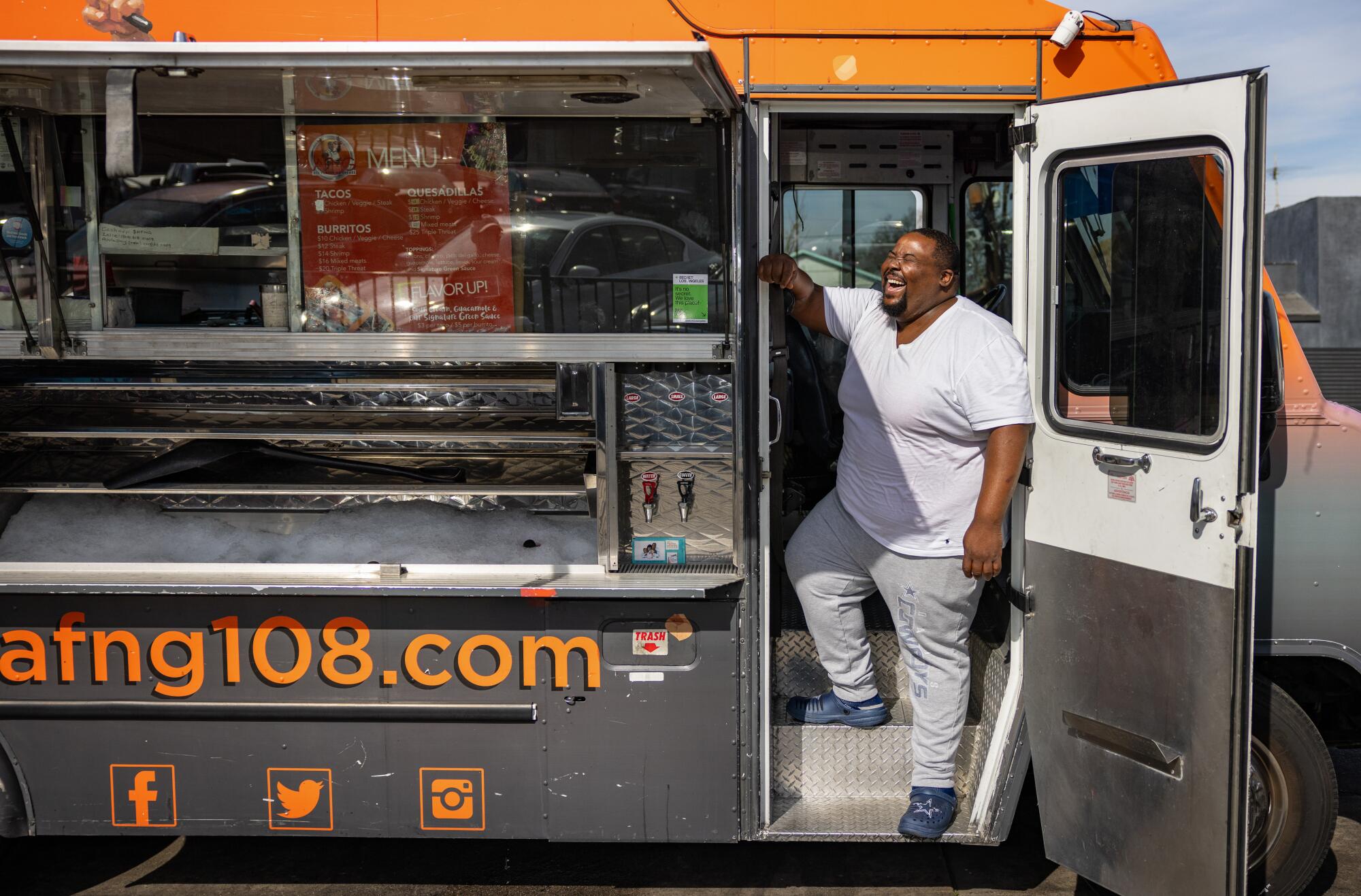 A man stands in the open door of a food truck