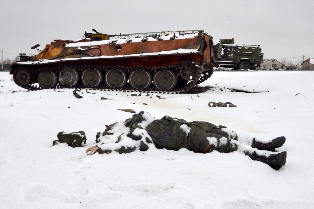 A body lies near a tank in a snow-covered landscape.