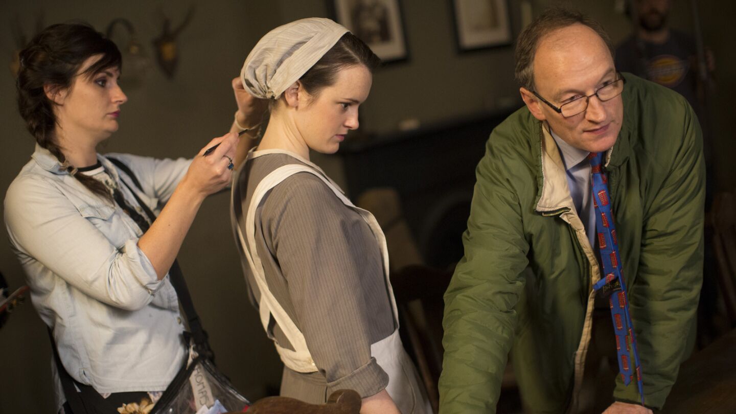 Makeup and hair artist Amy Boyd touches up Sophie McShera on set, as historical advisor Alastair Bruce waits for a scene of "Downton Abbey" in the downstairs servant quarter set at Ealing Studios in West London.