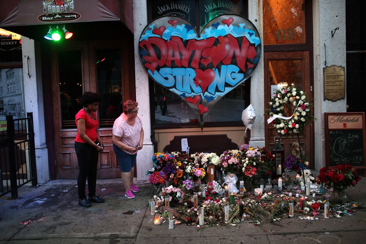 People look over a memorial to the nine people killed and 27 injured in the Aug. 4 mass shooting East 5th Street in Dayton, Ohio. 