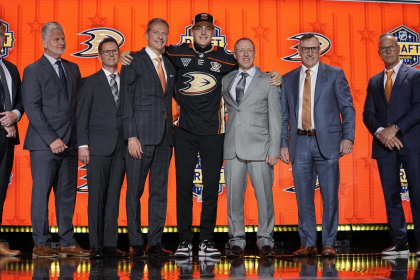 Leo Carlsson poses with Anaheim Ducks officials after being picked by the team during the first round of the NHL hockey draft Wednesday, June 28, 2023, in Nashville, Tenn. (AP Photo/George Walker IV)