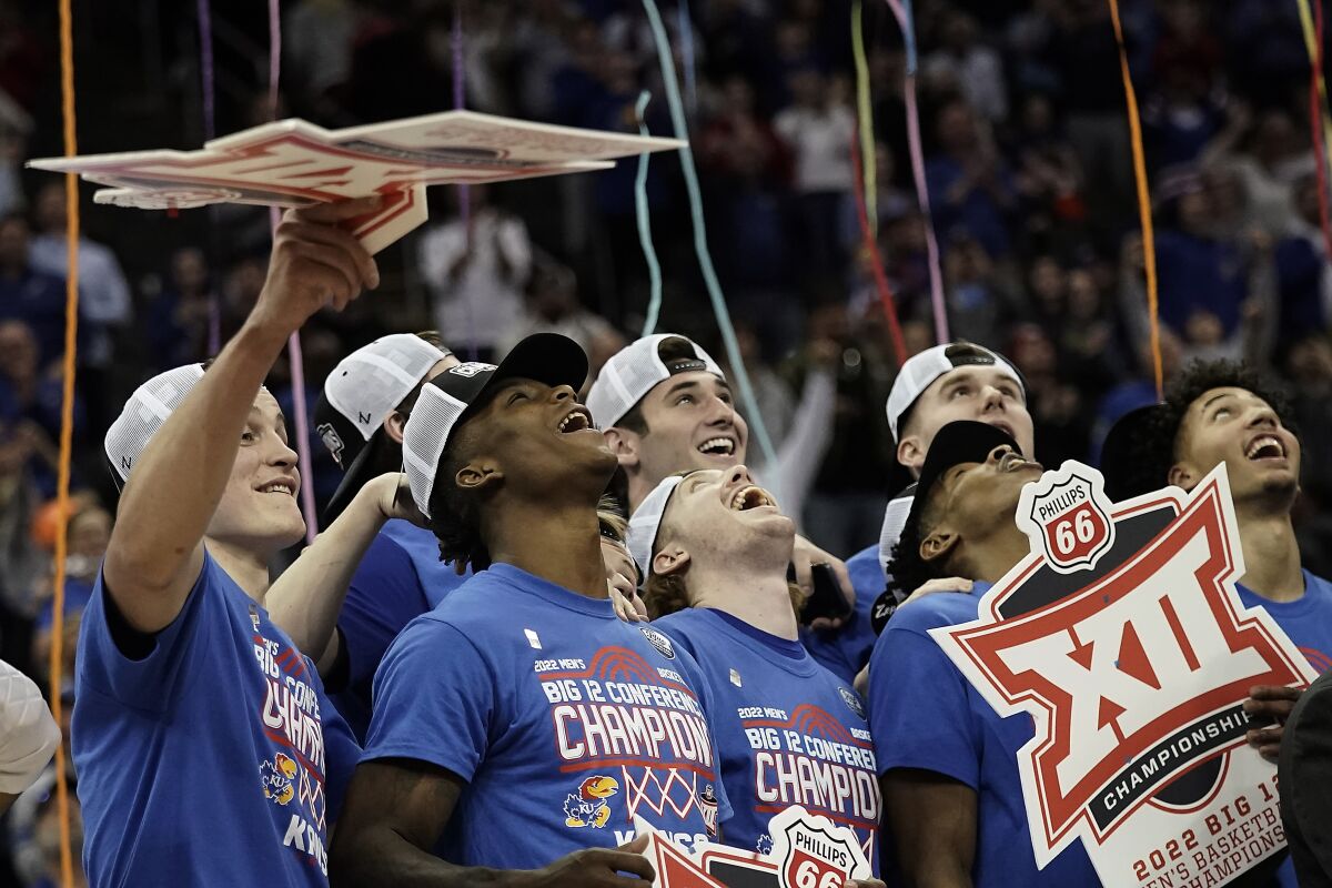 Kansas players celebrate after their NCAA college basketball championship game against Texas Tech in the Big 12 Conference tournament in Kansas City, Mo., Saturday, March 12, 2022. Kansas won 74-65. (AP Photo/Charlie Riedel)