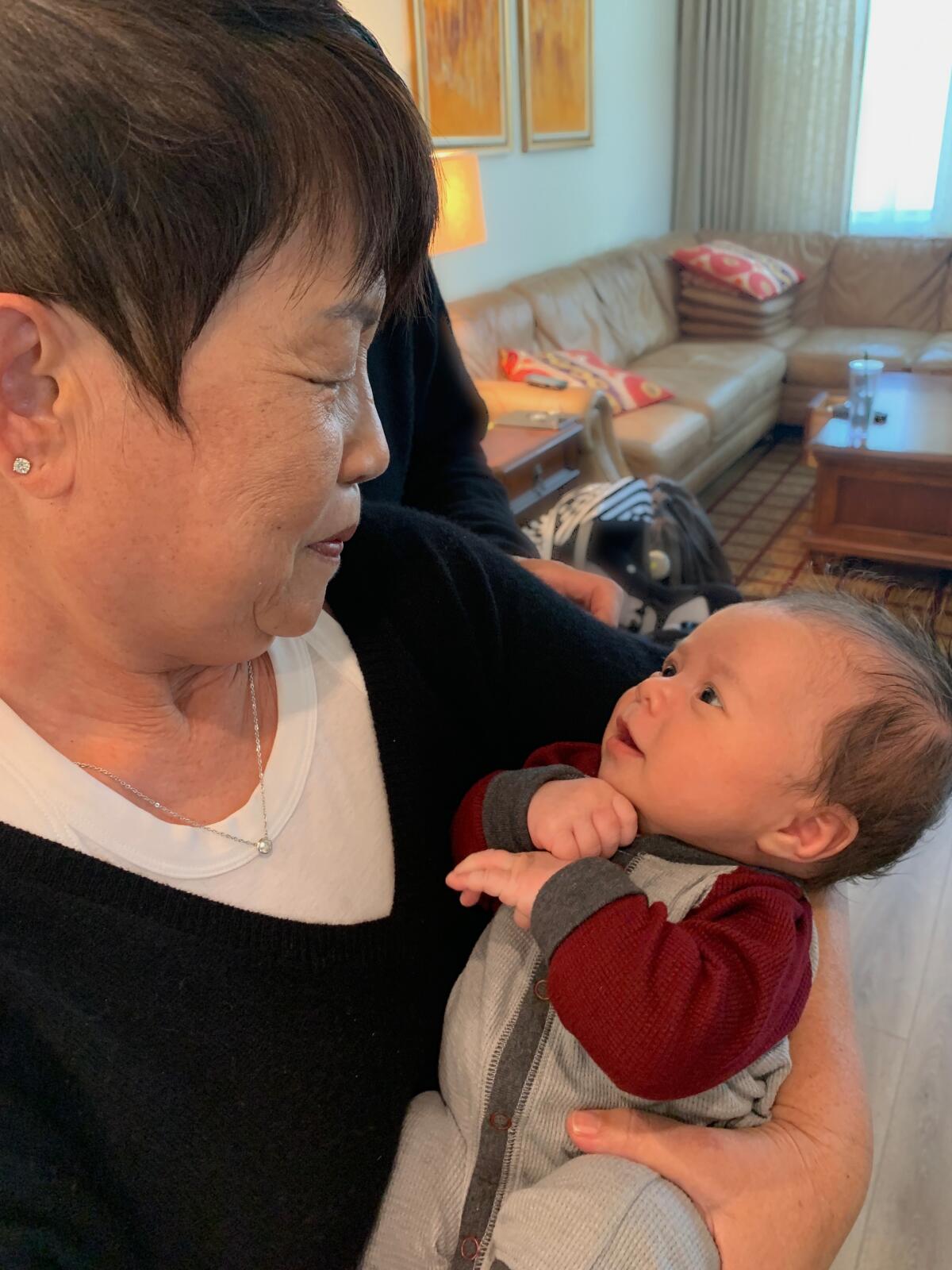 Jawoo Chon holds her new grandson, Colton for the first time following her COVID-19 vaccination. 