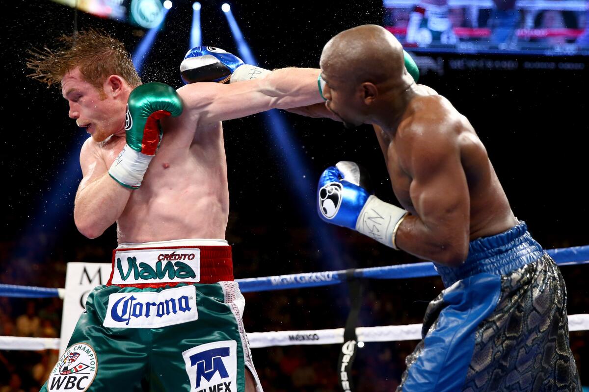 LAS VEGAS, NV - SEPTEMBER 14: (R-L) Floyd Mayweather Jr. throws a right to the head of Canelo Alvarez during their WBC/WBA 154-pound title fight at the MGM Grand Garden Arena on September 14, 2013 in Las Vegas, Nevada. (Photo by Al Bello/Getty Images)