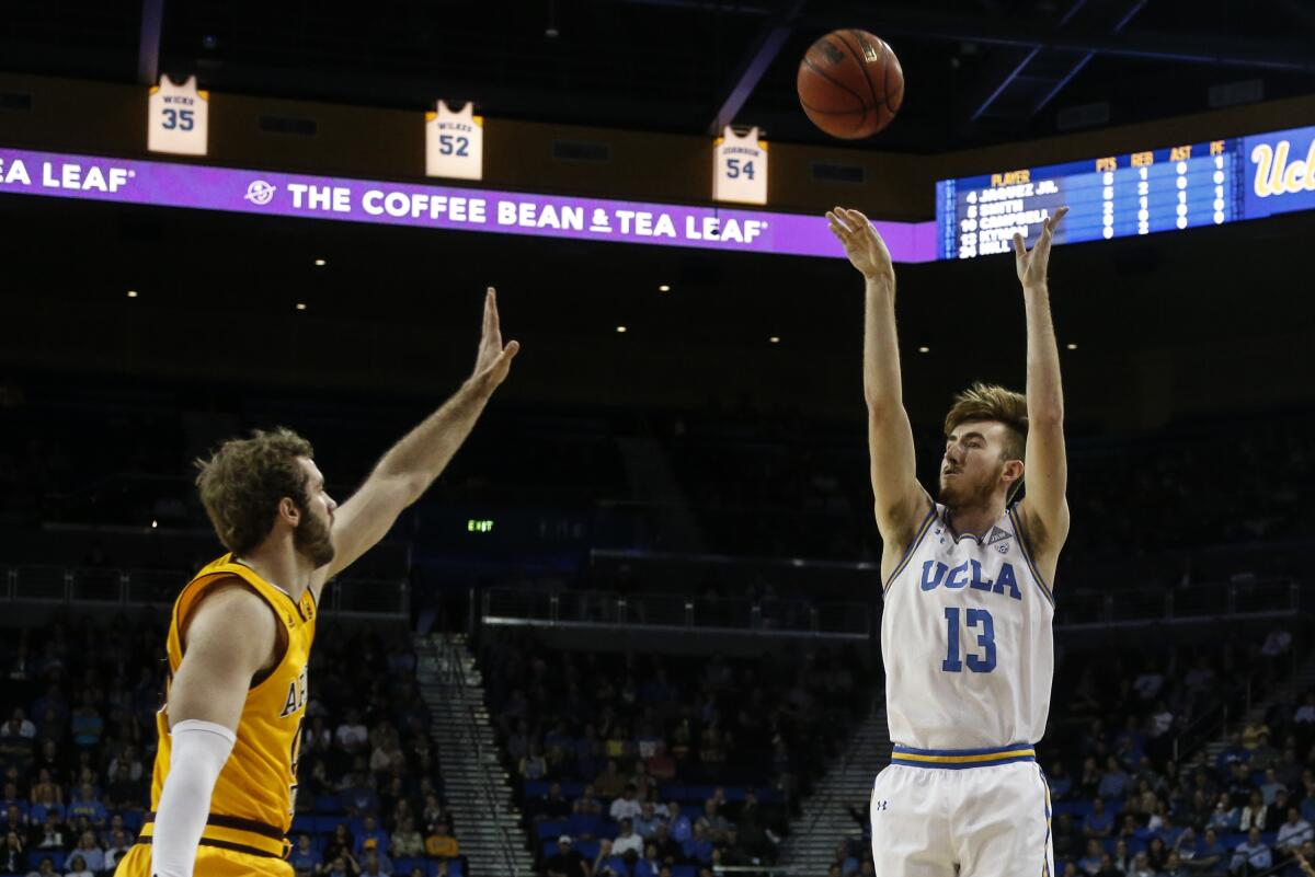 UCLA guard Jake Kyman shoots over Arizona State forward Mickey Mitchell during the Bruins' win Thursday at Pauley Pavilion.