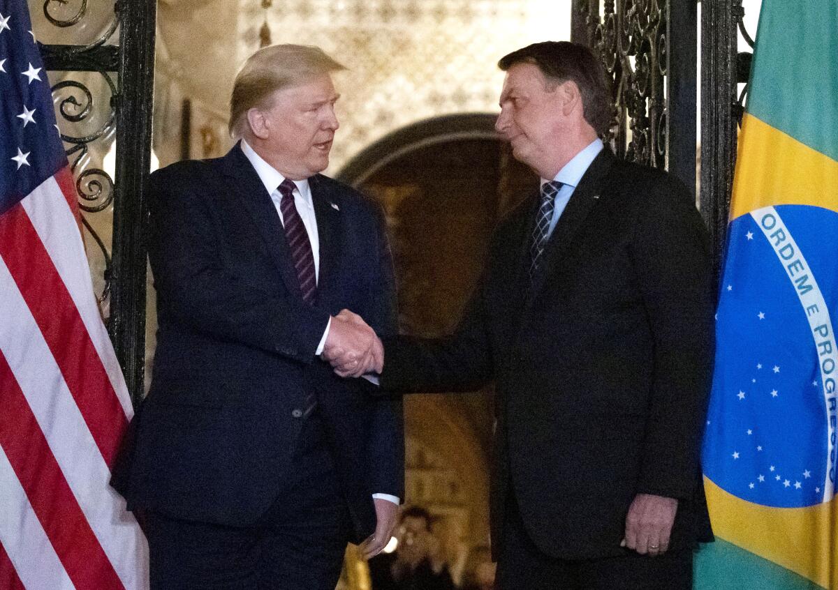 President Trump shakes hands with Brazilian President Jair Bolsonaro.