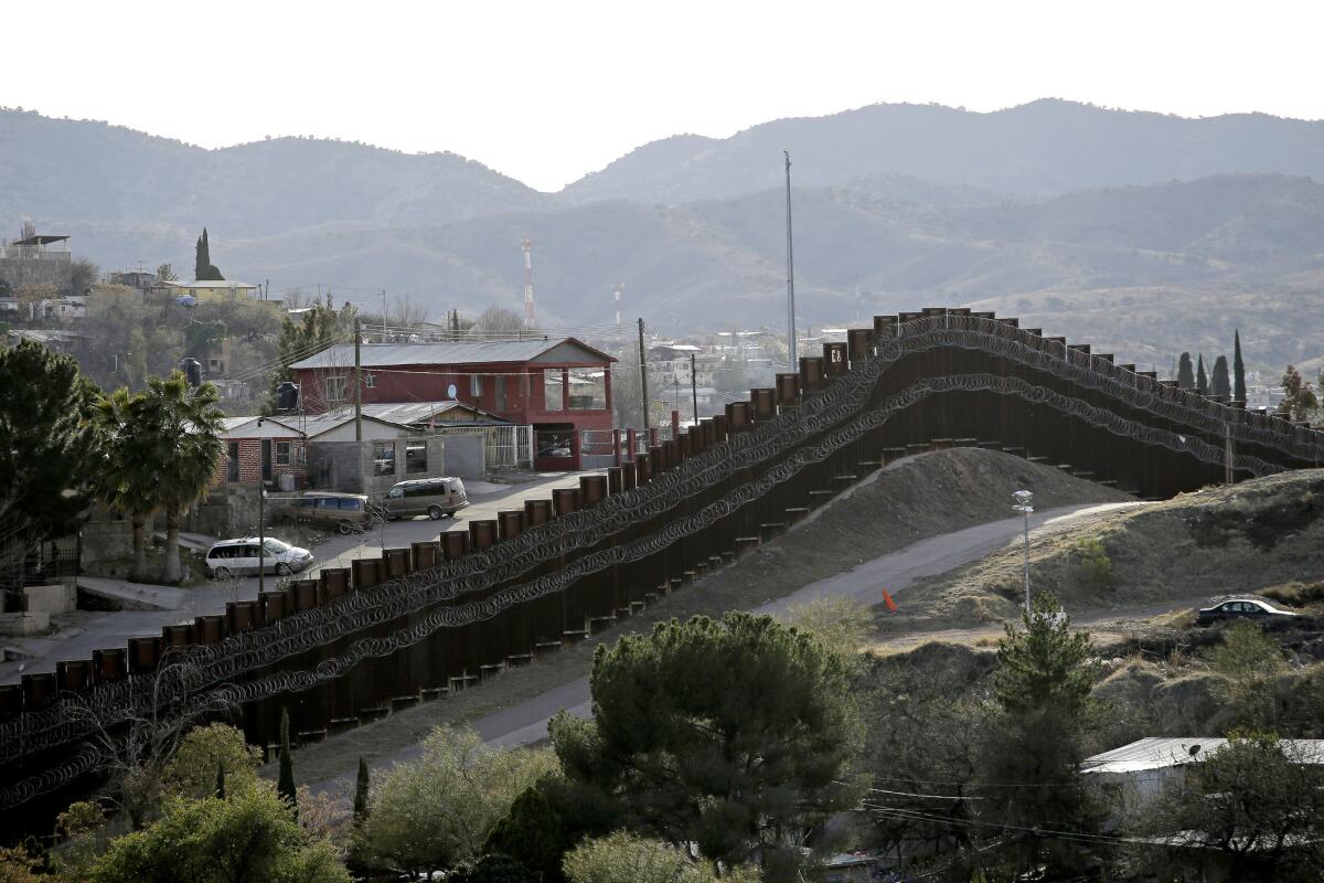 Valla fronteriza reforzada con un tendido doble de alambre de navajas separa a Nogales, México (i) de Nogales, Arizona.