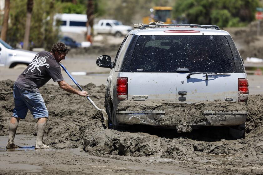 Cathedral City, CA, Wednesday, August 23, 2023 - Steve Gold shovels mud from his car on Horizon Rd. in the aftermath of Tropical Storm Hilary. (Robert Gauthier/Los Angeles Times)