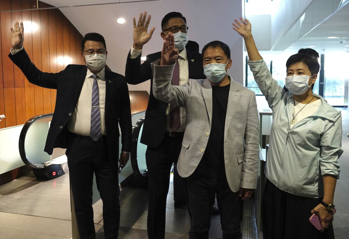 Hong Kong pro-democracy legislators wave after handing in their resignation letters.