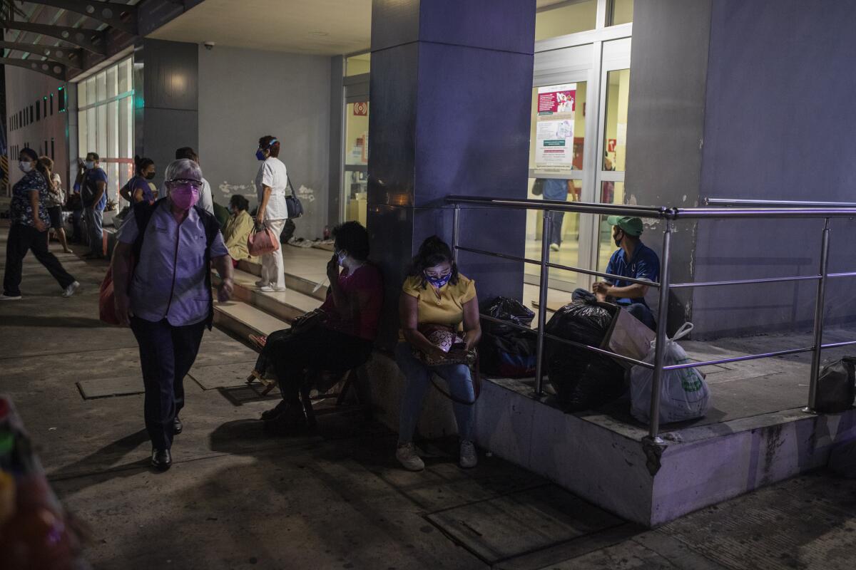 People sit outside a hospital