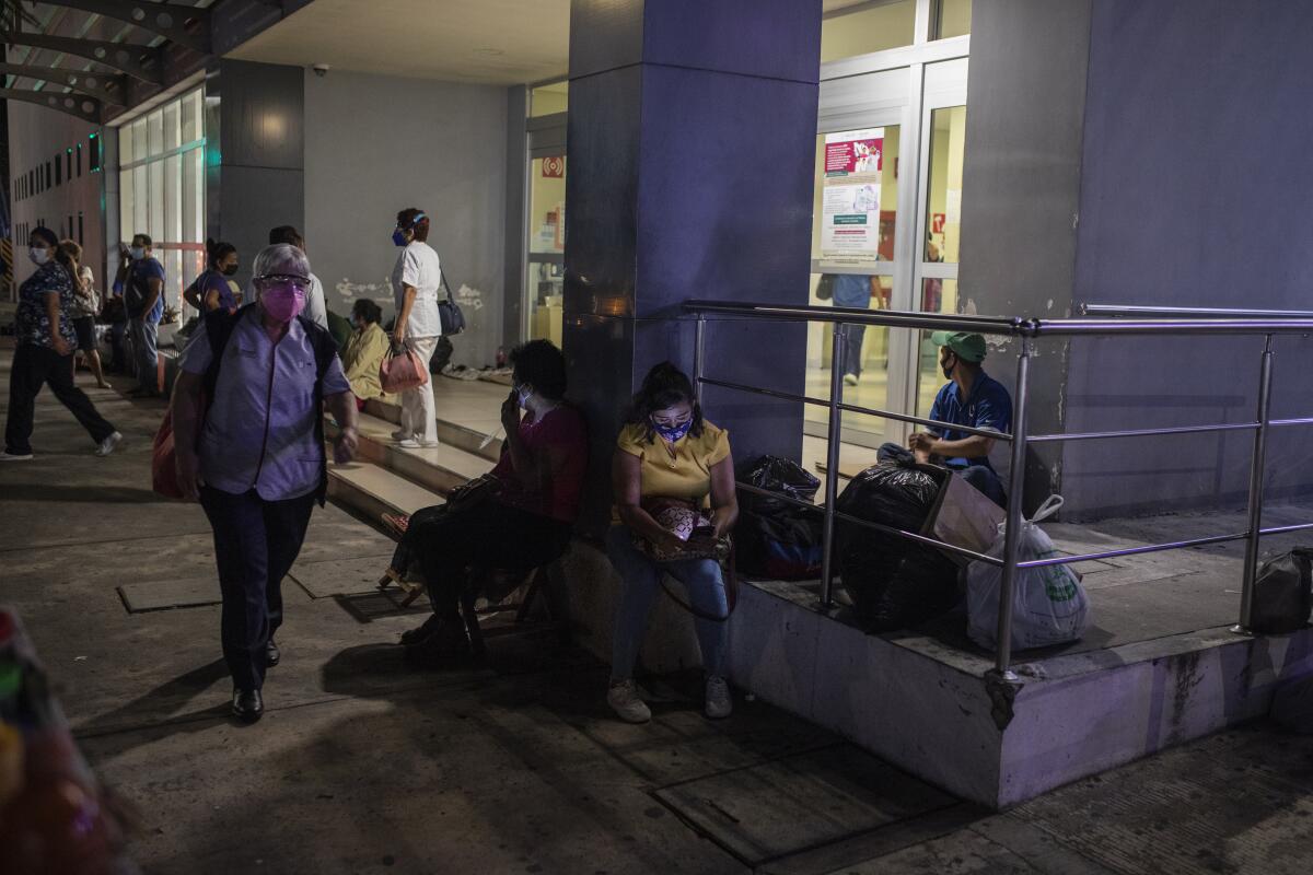 People sit outside a hospital 